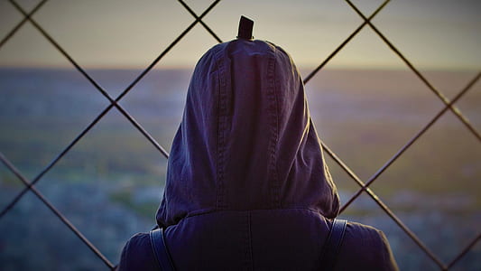 person wearing pink jacket facing chain-link fence thumbnail