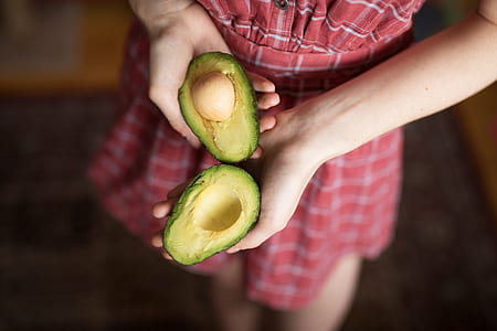 person holding slice of avocado thumbnail