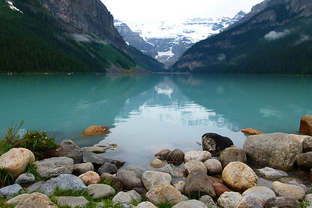 body of water near mountain during daytime thumbnail