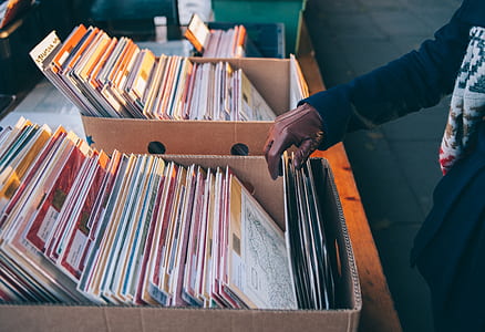 person with brown gloves choosing vinyl sleeve thumbnail