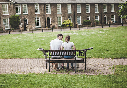 man and woman sitting on bench in front of building during daytime thumbnail