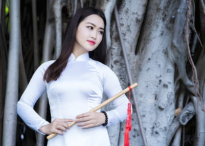 woman holding brown wooden flute thumbnail