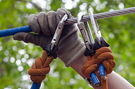 Person in Gray and Beige Gloves Holding on Gray Cable Wire thumbnail