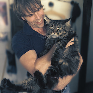 selective focus photography of man holding cat thumbnail