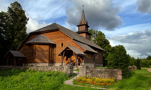 brown wooden church beside garden thumbnail