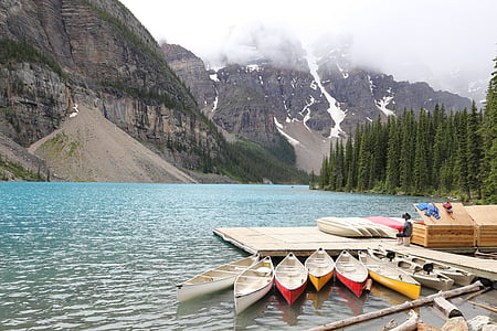 assorted-color canoe on body of water at daytime thumbnail