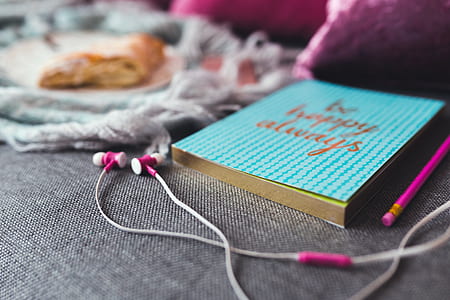 White and Pink Earphones on Gray Textile thumbnail