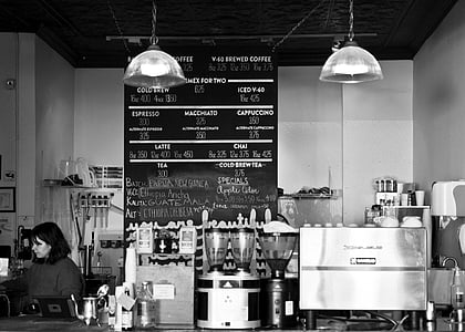 grayscale photo of woman sitting inside cafe thumbnail