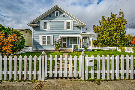 white and blue wooden house with open field under white skies at daytime thumbnail