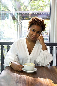 Woman Wearing White Deep V-neck Long-sleeved Blouse Holding White Ceramic Teacup thumbnail
