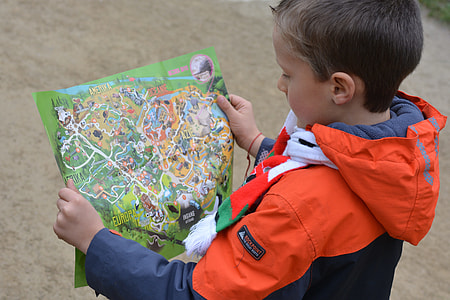 boy wearing orange and blue hoodie holding a green map thumbnail