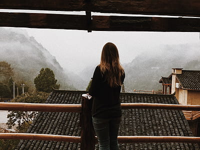 woman standing beside brown wooden rails thumbnail