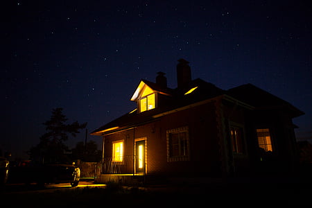 brown wooden 2-storey house with open lights thumbnail