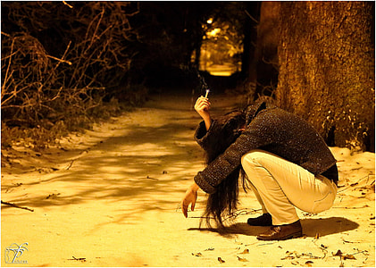woman in black long-sleeved shirt and gray denim jeans sitting at nighttim thumbnail
