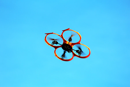red quadcopter flying on sky thumbnail