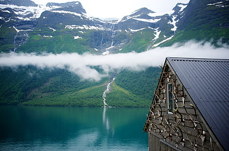 house beside lake on the foot of the mountain thumbnail