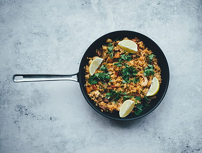 top view of frying pan with fried rice and four slices of lemons thumbnail