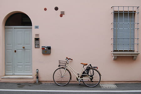 white city bike parked beside house thumbnail