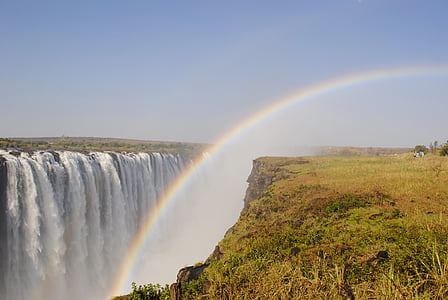 rainbow beside waterfall during daytime thumbnail