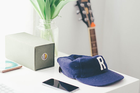 blue fitted cap beside smartphone on table thumbnail