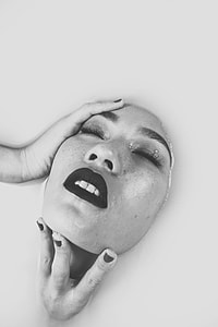grayscale photo of woman holding face thumbnail