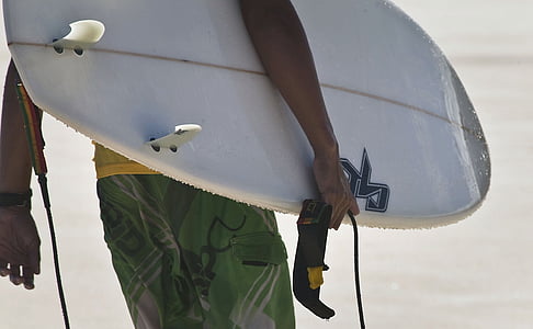 man wearing green shorts carrying white surfboard thumbnail