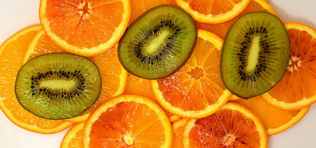 Kiwi and Orange fruit slices on white surface thumbnail