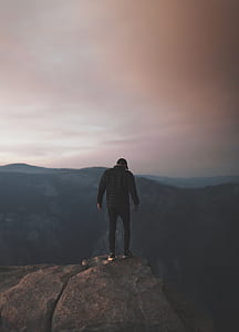 man standing on the tip of rock thumbnail