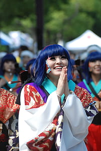 woman wearing red, white, and green long-sleeved dress with praying hands smiling thumbnail