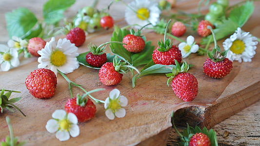 strawberries and white daisy flowers on table thumbnail