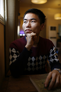 man head resting on fist near the window thumbnail