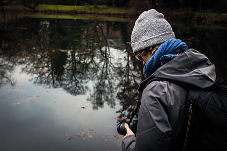 man standing beside body of water thumbnail