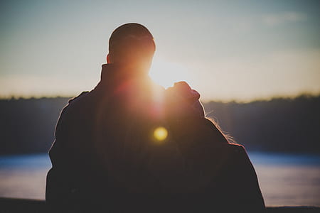 silhouette of couple facing body of water thumbnail