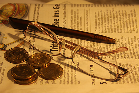 eyeglasses beside silver-colored coins thumbnail