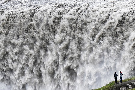 two person standing on mountain while watching waterfalls thumbnail