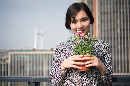 woman holding flowers in pot thumbnail