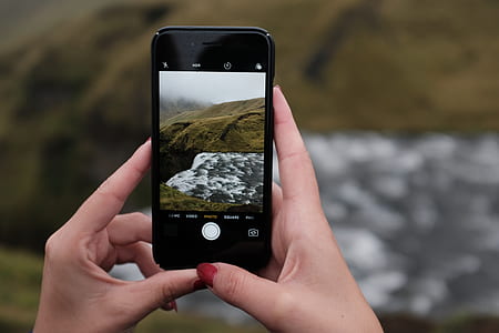 person taking photo of mountain range using space gray iPhone 6 thumbnail