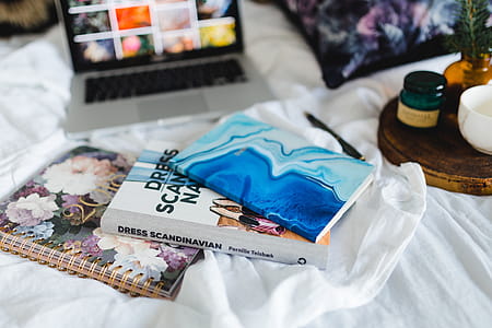 Bed full of pillows and notebooks with Apple gadgets thumbnail