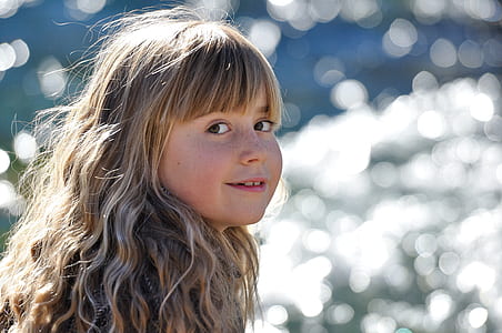 selective focus photography of girl near body of water thumbnail