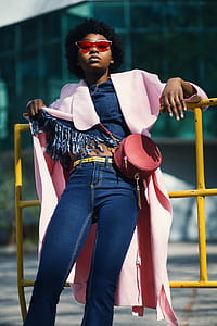 Woman Wearing Jeans Leaning on Yellow Metal Bar thumbnail