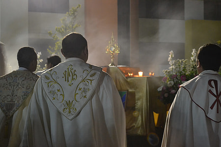 priest standing in front of altar thumbnail