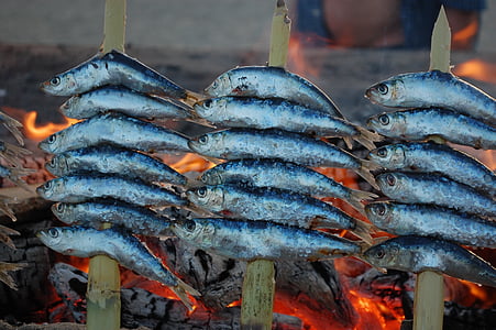 fish on bamboo skewers grilling on fire thumbnail