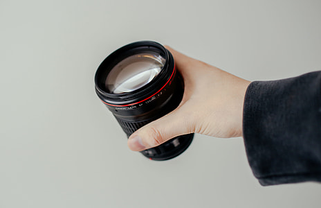 person holding DSLR camera lens thumbnail