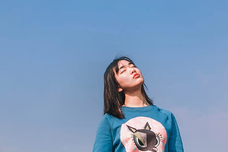 woman wearing blue and white crew-neck top during daytime thumbnail