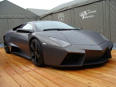 gray Lamborghini Huracan parked on wooden floor near gray tent thumbnail
