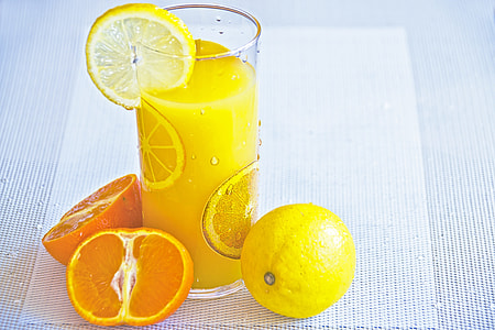 clear drinking glass with yellow liquid near lemons thumbnail