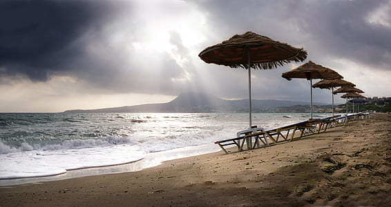 seats with parasols near seashore thumbnail
