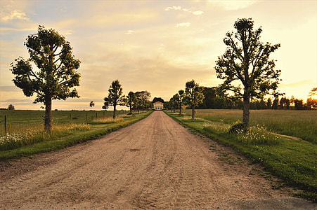 white concrete house in between green grass meadow during daytime thumbnail