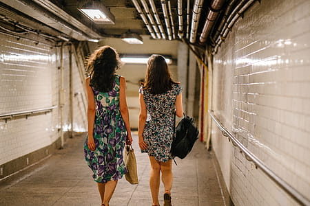Two Women Carrying Bags While Walking in Tunnel thumbnail