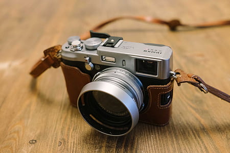 gray point-and-shoot camera on brown wooden surface thumbnail